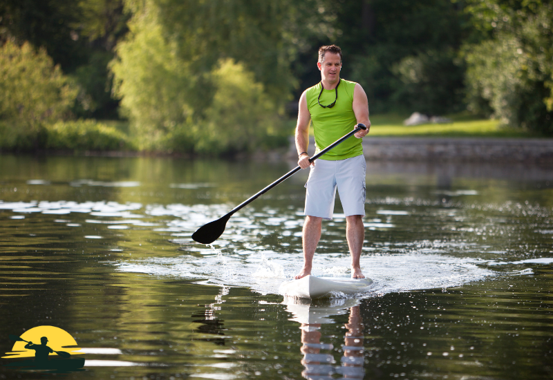 A man is riding with a paddle board in the water