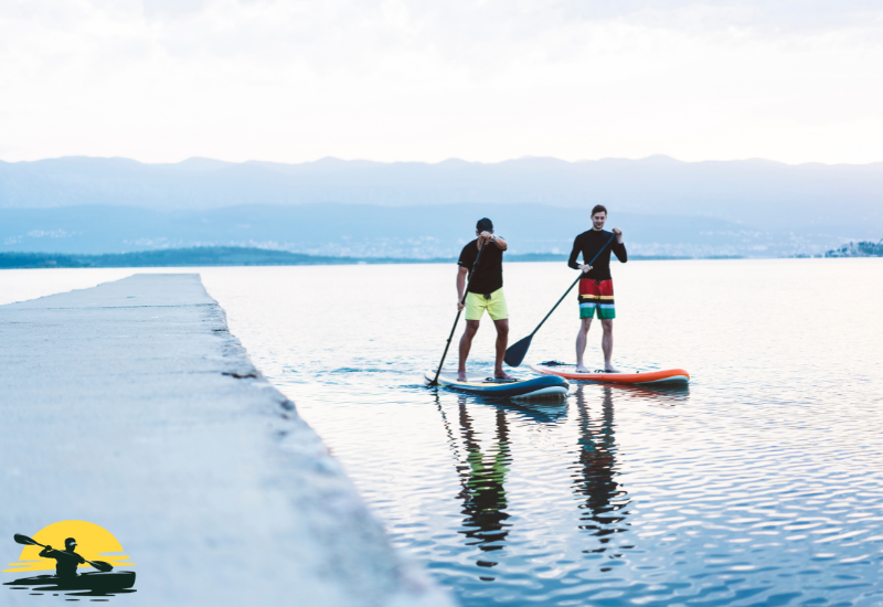 Two mens are paddling a board